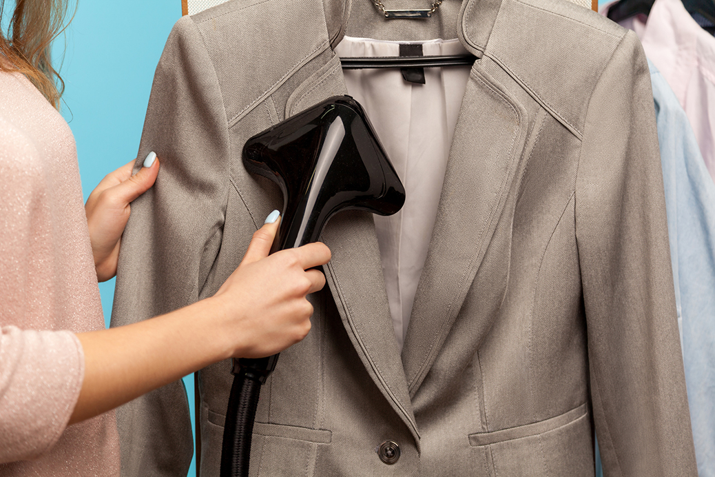 Closeup Female Hand Steaming Business Suit At Dry cleaner, Advertisement Of Professional Services Washing